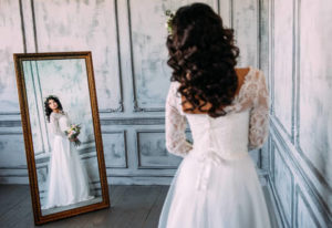 Разглядывать платье в зеркале